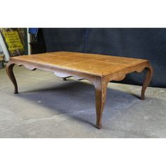 an old wooden table sitting on top of a cement floor