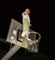 a man standing on top of a basketball hoop