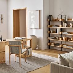 a living room filled with furniture and bookshelves next to a wall mounted book shelf