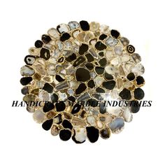 an assortment of black, white and gold glass pebbles on top of eachother