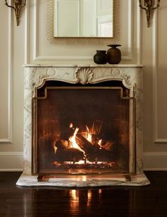 a fire place with a mirror above it