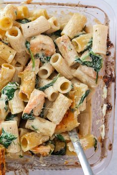 a glass dish filled with pasta and spinach