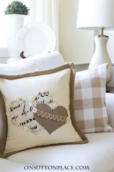 a white couch with some pillows on it and a pillow that says i love you