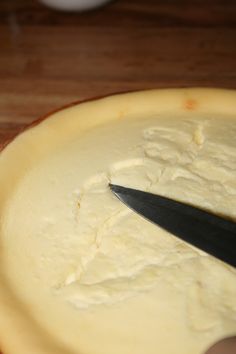 a person cutting cheese with a large knife