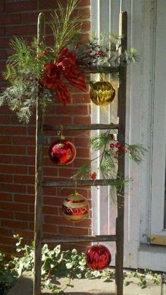 a ladder with ornaments hanging from it's sides on a brick wall next to a window