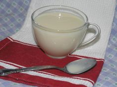 a cup of milk and a spoon on a napkin