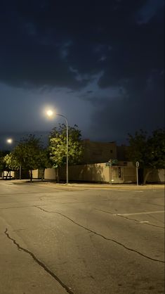 an empty parking lot at night with street lights