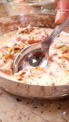 a person holding a spoon in a bowl of food