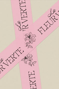 two pink ribbons with black writing on them