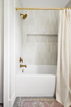 a white bath tub sitting next to a shower with a curtain on it's side