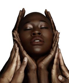 a woman holding her hands up to her face with both hands on her head and eyes closed