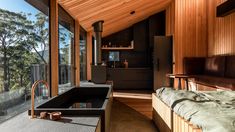 a large bath tub sitting inside of a bathroom next to a wooden wall and floor