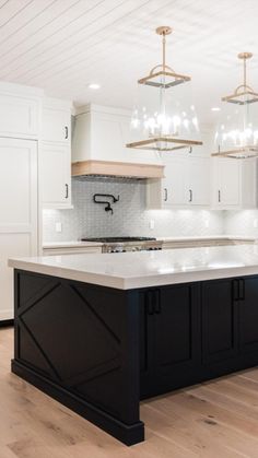 a kitchen with white cabinets and black island