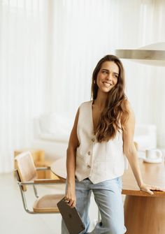 a woman standing in front of a wooden table