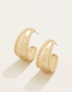 Classic style meets trending style in our Milly Hoop Earrings. Subtle hammered textured 18kt gold plating curves into a chunky hoop with studded edges. You'll reach for these lightweight beauties day after day - season after season. White And Gold Earrings, Gold Hoco Jewelry, New Years Earrings, Cute Gold Earrings, Jewelery Earrings, Good Earrings, Aesthetic Gold Jewelry, Chunky Gold Earrings, Jewelry Trending