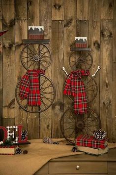 two red and black plaid christmas decorations in front of a wooden wall with the word joy spelled out