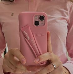 a woman is holding up her phone case with an ad on the back in pink