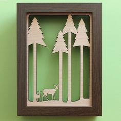 a wooden cutout of trees with a deer in the woods