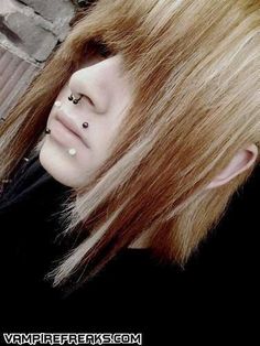 a woman with piercings on her nose and long hair is posing for the camera