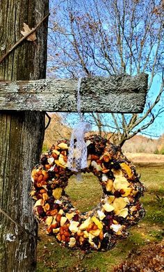 a wreath hanging on the side of a wooden cross