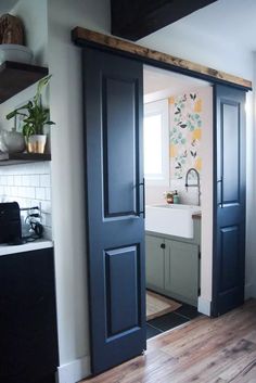 an open door leading to a kitchen with wooden floors