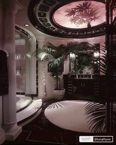 the bathroom is decorated in black and white with palm trees on the wall, round mirror above the bathtub