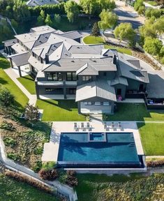 an aerial view of a large house with a swimming pool in the middle of it