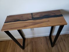 a wooden table with black metal legs and a wood slab on the top that looks like it has been cut in half