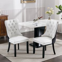 a white dining table with two chairs