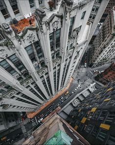 an aerial view of a city with tall buildings and cars driving down the street in front of them