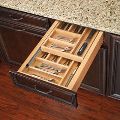 an open drawer with utensils in it