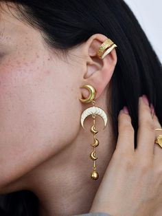 Add a touch of celestial charm to your style with these stunning Luna Earrings. Handcrafted with precision, these earrings feature a delicate crescent moon design, beautifully enameled to create a unique, elegant look. Made from high-quality brass and finished with a luxurious gold-filled coating, they offer durability along with timeless beauty. The lightweight dangle design ensures comfort, making them perfect for everyday wear or special occasions. Whether you're treating yourself or gifting Luxury Unique Enamel Earrings, Luxury Hand-tooled Jewelry For Festivals, Mystical Moon Shaped Earrings, Gold Moon-shaped Earrings, Celestial Metal Jewelry, Enamel Dangle Single Earring, Celestial Teardrop Pierced Jewelry, Adjustable Moon Charm Earrings, Gold Moon Phase Drop Earrings