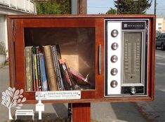 an old fashioned radio sitting on top of a wooden box filled with books and dvds