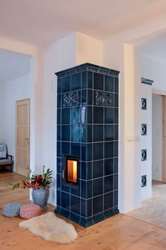 a living room with a fireplace in the center and wood flooring on the other side