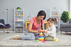 a woman playing with her child on the floor