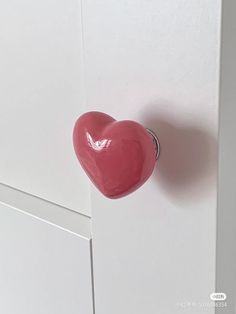 a heart shaped door handle on a white cabinet