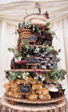 a wedding cake made out of cupcakes and pastries on a tree stump