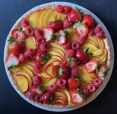 a pie topped with sliced fruit on top of a table