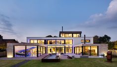 a modern house with large glass windows at dusk