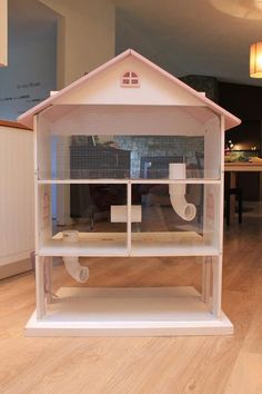 a white bird house sitting on top of a hard wood floor