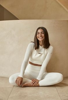 a woman sitting on the floor in white clothes