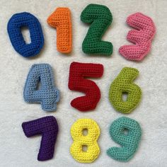 crocheted numbers laid out in different colors on a white surface with one number missing