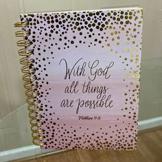 a pink and gold spiral notebook with the words, with god all things are possible