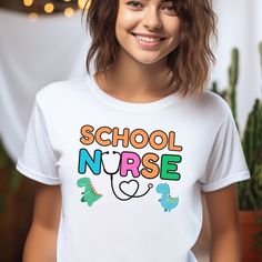 Cute School Nurse Tshirt: Discover cozy and stylish tees celebrating school nurses! Perfect for honoring their dedication or gifting to your favorite healthcare hero. Made from our BELLA AND CANVAS brand, this tee offers style and comfort. Here's what you need to know before you make your purchase: 1.Unisex Adult Sized Shirts. They're not women's fitted shirts, so for a more fitted look, consider sizing down. 2.Rolled Sleeves in pictures are for styling purposes only. 3.Props used in photos are NOT included with purchase. PRINT DESIGN 1.This is a Direct-To-Garment printed item, ensuring durability without cracking or peeling. 2.The ink is printed INTO the fabric, ensuring longevity. WASHING INSTRUCTIONS 1.Wash inside out, in cold water, on a gentle cycle. Tumble dry low or let air dry. 2.D Funny Text Crew Neck T-shirt For College, College T-shirt With Funny Text And Short Sleeves, Back To School Text Print Crew Neck T-shirt, Back To School Funny T-shirt With Text, School Graphic Tee With Name Print, Graphic Tee With Name Print For School, Funny Letter Print T-shirt For Back To School, Funny Back To School T-shirt With Text, White Casual Nursing Shirt