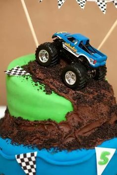 a monster truck cake with green frosting and dirt on the top is ready to be eaten