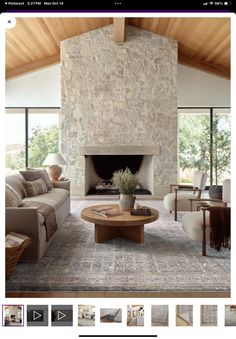 a living room filled with furniture and a fire place in front of a stone fireplace