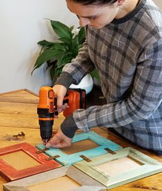 a woman is using a drill to cut out pieces of wood