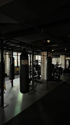 an empty gym with punching bags and equipment