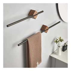 two metal and wood towel racks on the wall next to a white vase with a plant in it