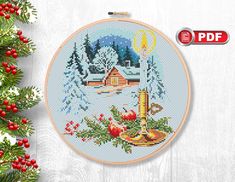 a cross stitch christmas scene on a wooden background with pine branches and red berries in the foreground